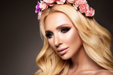 Naklejka premium Beautiful Woman with Long Curly Hair, Perfect Makeup and Wreath of Spring Flowers