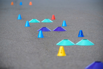 Cones for slalom on roller skates stand on asphalt, inline