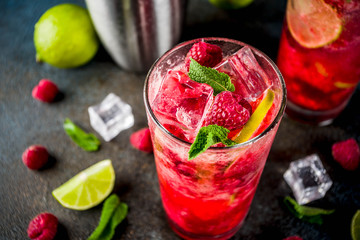 Iced summer drink cocktail, Raspberry and lime lemonade with fresh mint and lime, dark blue rusty background copy space - obrazy, fototapety, plakaty