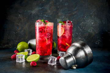 Iced summer drink cocktail, Raspberry and lime lemonade with fresh mint and lime, dark blue rusty...