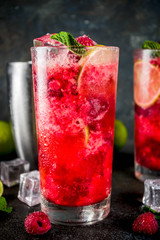 Iced summer drink cocktail, Raspberry and lime lemonade with fresh mint and lime, dark blue rusty...