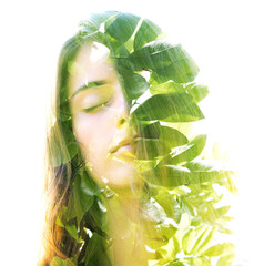 Double exposure of a young natural beauty combined with bright shining tropical leaves