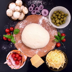 Pizza with meat Vegetables and Spices on a black background. Top view.