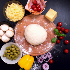 Pizza with meat Vegetables and Spices on a black background. Top view.
