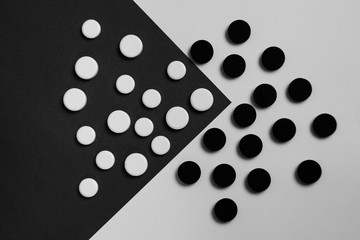 Assortment of various colourful pills on black and white background. Medication and prescription pills background.