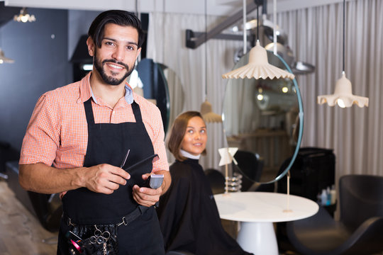 smiling man hairdresser and woman in salon
