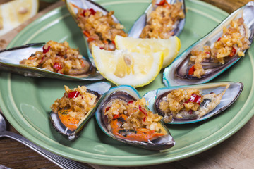 Delicious seafood mussels with with sauce and parsley. Lemon