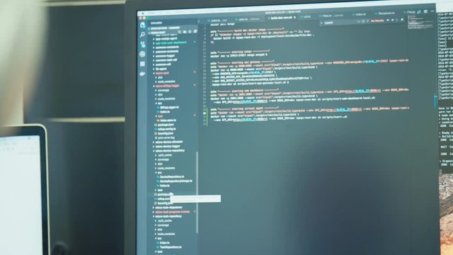 computer programmer sitting in front of a screen coding software