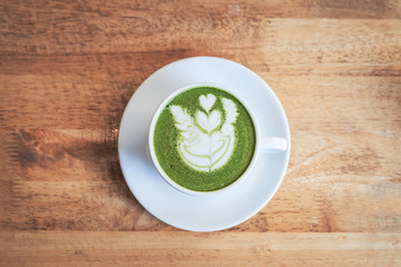 Green tea matcha latte in a cup on wooden background