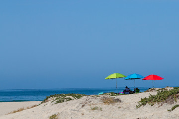 Three colorful beach umbrellas