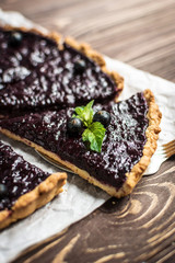 Homemade summer berry tart on a wooden background