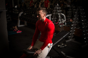 the sportsman is engaged in an exercise room, pumps muscles, a biceps and a press