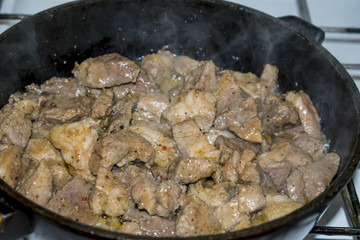 Meat fried on a cast-iron frying pan