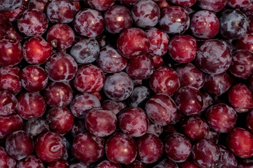 Fresh ripe red plums as a background