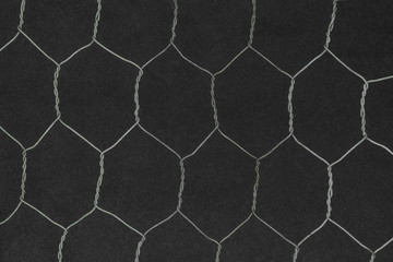 Hexagon shape metal fence on black background surface