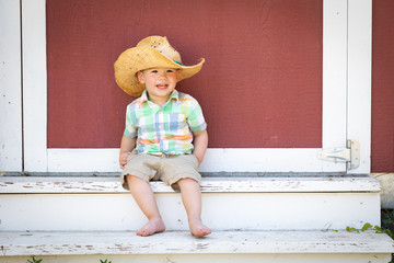 Young Mixed Race Chinese and Caucasian Boy Wearing Cowboy Hat Relaxing On The Steps