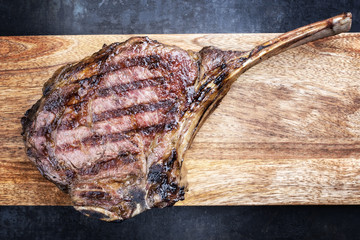 Barbecue dry aged Wagyu Tomahawk Steak als Draufsicht auf Schneidebrett