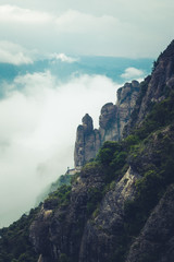 Mountains near Montserrat Abbey in Spain. Clouds and fog. Trees on cliffs.