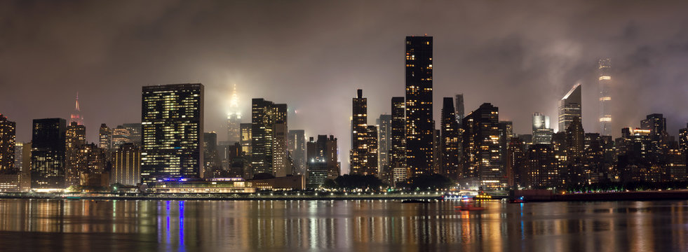 Manhattan skyline at night with reflections, NYC, USA.