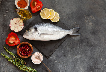 Raw dorado fish with spices on cutting board
