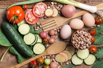 Top view of tomatoes, cucumber, onion,potato,eggs and beans on wooden table. Cooking table. Eat healthy. Fresh organic vegetables.