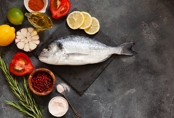 Raw dorado fish with spices on cutting board