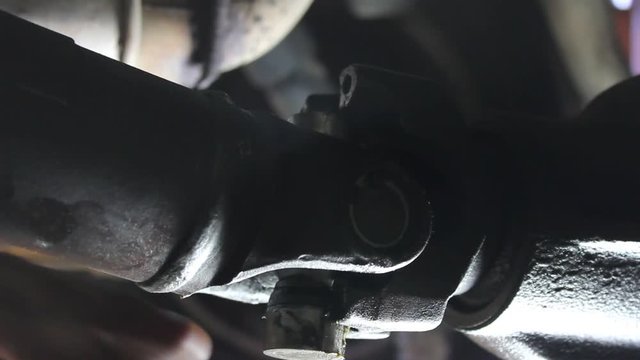 Automotive technician reassembles and drive line axle universal joint, and tightens the bolts using an 1/4 drive impact.