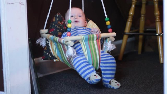 Little baby boy bouncing up in his jumper swing. Swing is homemade and crafty.