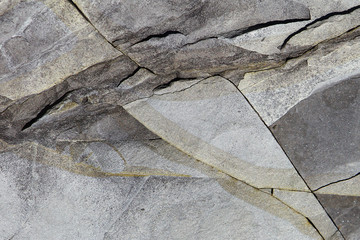 Dark grey stone surface texture with cracks. Limestone rock background.