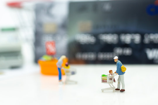 Miniature people : Shopper with shopping discount items, payment by credit card. Image use for Business and shopping concept.
