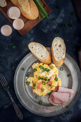 Scrambled eggs with tomatoes on dark background