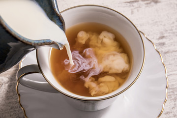  Milk being poured into a cup of hot tea