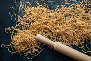 Dried egg noodles. Raw Fresh Spaghetti on blue wooden background. Top view