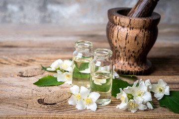 Obraz na płótnie Canvas Essential jasmine oil with jasmine flowers and mortar on wooden background.