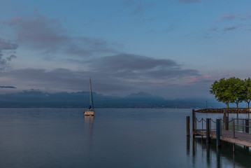 Fototapeta na wymiar Colorful sunrise on the marina of Lausanne on the Lake Leman in summer with the view of the Swiss Alps in background - 13