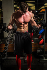 the sportsman is engaged in an exercise room, pumps muscles, a biceps and a press