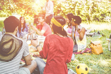 Fototapeta na wymiar Happy millennial friends doing picnic outdoor in nature