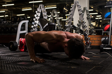 the sportsman is engaged in an exercise room, pumps muscles, a biceps and a press