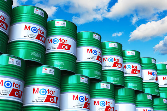 Group of stacked barrels with motor oil lubricant against blue sky
