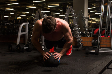 the sportsman is engaged in an exercise room, pumps muscles, a biceps and a press