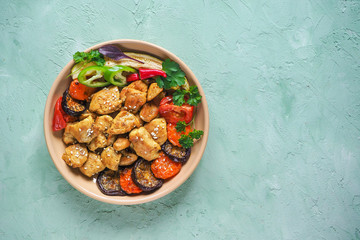 Pieces of baked meat with grilled vegetables on a plate.