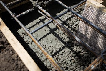 Close up wire mesh and wet cement in concrete floor pouring process