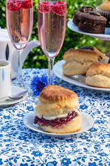 Afternoon tea with cakes and traditional English scones with strawberry jam and clotted cream set...
