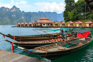 Long-tail boat and lakeside raft houses on Cheow Lan Lake, Khao Sok National Park in southern Thailand