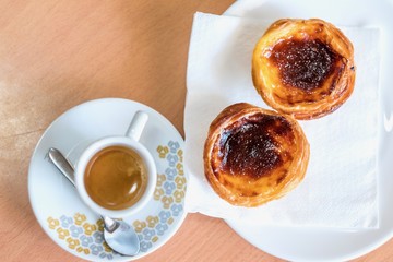 Top view of traditional Portuguese pastry and coffee