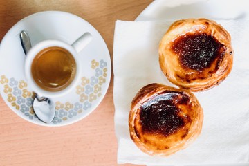 Top view of traditional Portuguese pastry and coffee