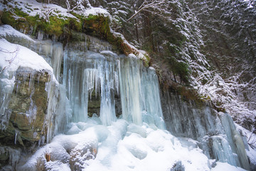 Frozen icicles on the rocks inside of the forest