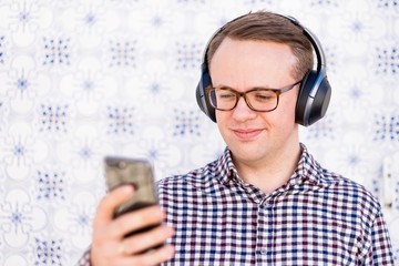 Young man with bluetooth headphones connected to smartphone