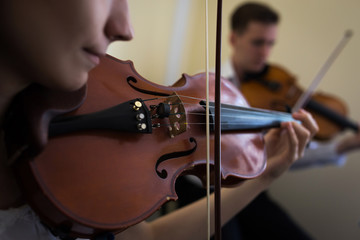 Girl playing the violin. Old violin close-up