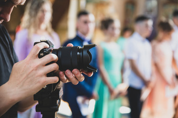 Fototapeta premium Professional videographer provides services of filming ceremonial event, matte toning effect 